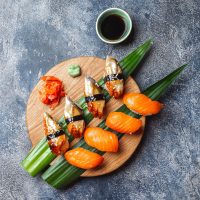 Sashimi sushi set on wooden board. Stone background. Top view.